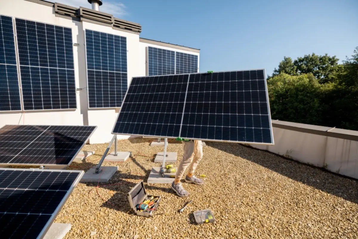 man installing solar panels on a rooftop
