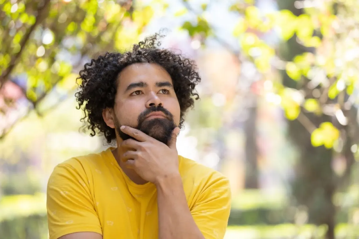 man standing at the park while thinking and looking
