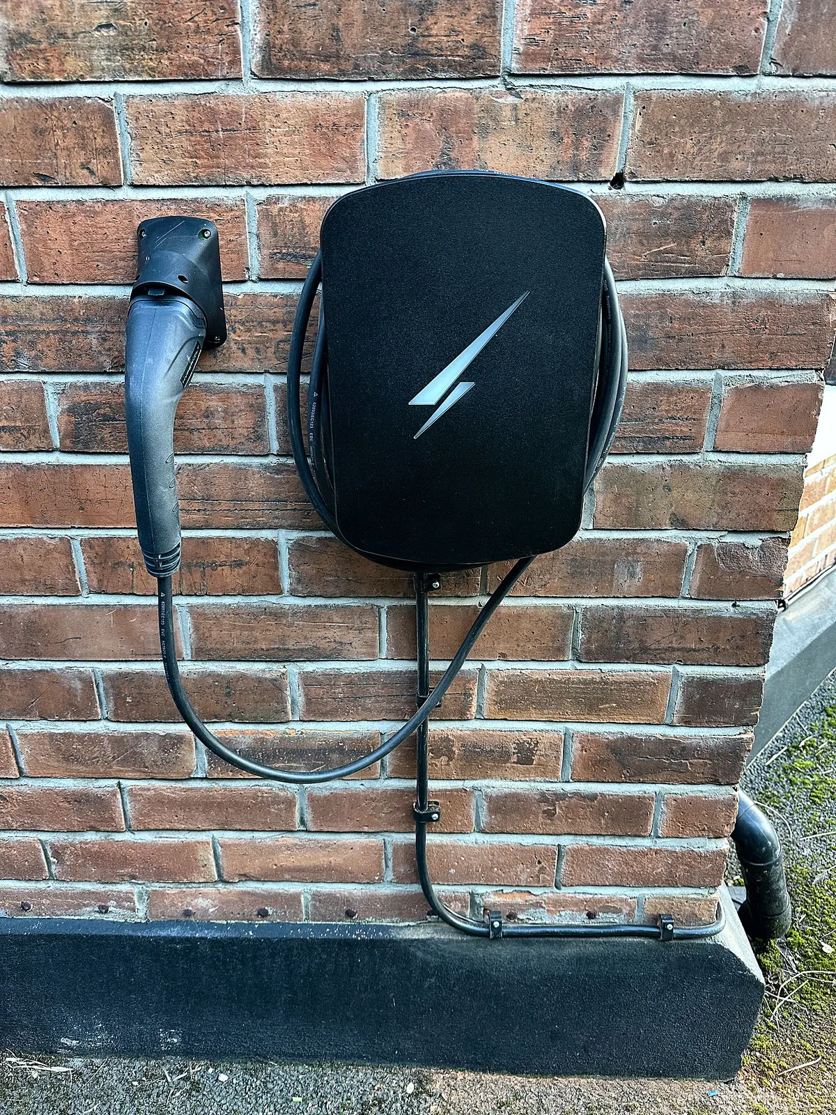 Hypervolt home EV charger installed by Glow on a brick wall