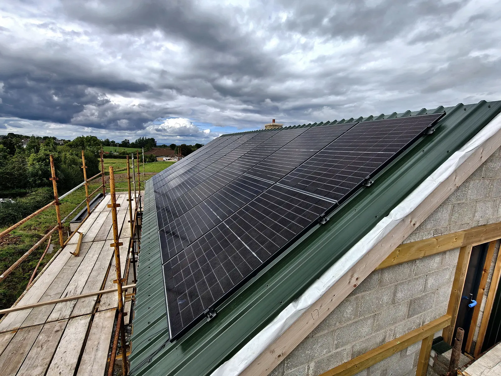 All-black solar array installed by Glow on a green metal roof